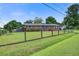 Quaint, fenced-in brick home with a lush lawn, blue shutters, solar panels, and detached garage at 1418 Kentwood Circle Cir, Charleston, SC 29412