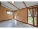 Bright sun room with tile flooring, exposed beams, and door leading to a large backyard at 1418 Kentwood Circle Cir, Charleston, SC 29412