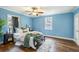 A blue bedroom featuring hardwood floors, a ceiling fan, and a large window at 1426 Bexley St, North Charleston, SC 29405