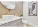 Stylish powder room features a round mirror, textured tile wall, unique faucet and gold accents at 1565 Juniper St, Charleston, SC 29407