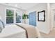 Serene main bedroom with large window views, blue closet doors, and a decorative mirror hanging on the wall at 1565 Juniper St, Charleston, SC 29407