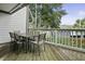 Covered porch featuring a wooden deck with a dining table, chairs and a view of the lush greenery at 1613 Live Oak Park, Seabrook Island, SC 29455