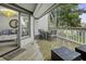 Covered porch featuring a wooden deck with a dining table and seating, accessible from the home's interior at 1613 Live Oak Park, Seabrook Island, SC 29455