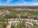 Overhead shot showcases a community with many homes surrounded by dense woodlands and clear blue skies at 1747 Towne St, Johns Island, SC 29455
