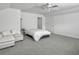 Bright bedroom features a ceiling fan, white walls, and cozy sitting area with a large bed and comfortable sofa at 1747 Towne St, Johns Island, SC 29455