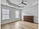 Bedroom features a tray ceiling with a ceiling fan, wood floors, and a traditional wood dresser plus bright windows at 1747 Towne St, Johns Island, SC 29455