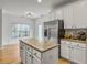 Open kitchen featuring a center island with granite countertop and stainless steel refrigerator at 1747 Towne St, Johns Island, SC 29455
