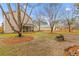 Spacious backyard with mature trees, established landscaping, and a cozy fire pit area at 186 Jupiter Ln, Summerville, SC 29483