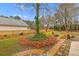 Landscaped backyard featuring a stone patio, brick pathway, and lush green foliage at 186 Jupiter Ln, Summerville, SC 29483