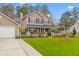 Well-maintained home featuring a green lawn, mature trees, and a two-car garage at 186 Jupiter Ln, Summerville, SC 29483