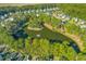 Aerial shot of a residential community with a pond, lush trees, and manicured lawns at 1901 Hubbell Dr, Mount Pleasant, SC 29466