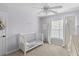 Bright Bedroom featuring a white crib, plush carpet, and a ceiling fan with decorative lighting at 1901 Hubbell Dr, Mount Pleasant, SC 29466
