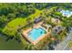 Aerial view of a community pool area, showcasing a large pool, clubhouse, playground, and surrounding green spaces at 1901 Hubbell Dr, Mount Pleasant, SC 29466