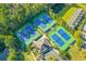 Overhead view of community tennis courts with blue and green surfacing, nestled among trees and townhomes at 1901 Hubbell Dr, Mount Pleasant, SC 29466