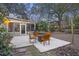 Outdoor patio area with a grill, square fire pit, wooden chairs and a screened in porch for relaxing and entertaining at 1942 Oak Tree Ln, Mount Pleasant, SC 29464