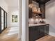 Stylish bar area with dark cabinetry, open shelving, wine storage, and beverage cooler at 215 Fell Pt, Daniel Island, SC 29492