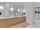 Bathroom featuring double sink vanity with natural wood cabinets and dual arched mirrors at 215 Fell Pt, Daniel Island, SC 29492
