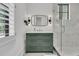 Green vanity in a bathroom with a white marble shower and a large window at 215 Fell Pt, Daniel Island, SC 29492