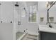 Modern bathroom features glass shower, shuttered window, and vanity with black hardware at 215 Fell Pt, Daniel Island, SC 29492