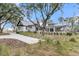 Beautiful white home with dark trim, manicured lawn, and long driveway at 215 Fell Pt, Daniel Island, SC 29492