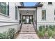Inviting front entrance with brick stairs, potted plants, and a stylish hanging light fixture at 215 Fell Pt, Daniel Island, SC 29492
