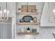 Kitchen detail featuring floating shelves with decor, stainless steel refrigerator, and pendant lighting at 215 Fell Pt, Daniel Island, SC 29492