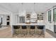 Bright, open kitchen features a spacious island with seating, stainless steel appliances, and stylish light fixtures at 215 Fell Pt, Daniel Island, SC 29492