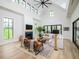 Bright living room with a fireplace, vaulted ceilings, lots of windows, and modern decor at 215 Fell Pt, Daniel Island, SC 29492