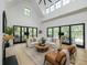Bright living room with fireplace, hardwood floors, modern furniture, and access to outdoor living space at 215 Fell Pt, Daniel Island, SC 29492