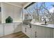 Outdoor kitchen area with stainless steel grill, sink, and white cabinets for convenient meal preparation at 215 Fell Pt, Daniel Island, SC 29492