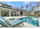 Luxurious backyard featuring a sparkling pool, comfortable lounge chairs, and outdoor dining area at 215 Fell Pt, Daniel Island, SC 29492