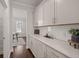 Well-lit pantry with white cabinets, quartz countertops, and view into dining area at 219 Seaworthy St, Summerville, SC 29486
