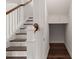 Wooden staircase with white rails adjacent to a hallway area with additional storage space at 219 Seaworthy St, Summerville, SC 29486