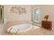 A luxurious bathroom featuring a soaking tub, tile surround, and decorative wall art at 2217 Beckenham Dr, Mount Pleasant, SC 29466