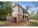 Charming home with green siding, brick foundation, screened porch, and outdoor staircase in a wooded setting at 2217 Beckenham Dr, Mount Pleasant, SC 29466