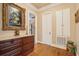 Hallway with hardwood floors and detailed trim includes cabinet storage and a decorative painting at 2217 Beckenham Dr, Mount Pleasant, SC 29466