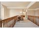 A long hallway on the second story with light colored carpet and wood railing at 2217 Beckenham Dr, Mount Pleasant, SC 29466