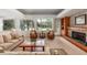 Comfortable living room featuring a stone fireplace, built-in shelving, and large windows overlooking lush greenery at 2710 Gnarled Pine, Seabrook Island, SC 29455