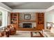 Cozy living room showcasing a stone fireplace, built-in shelves, plush seating, and large windows overlooking the outdoors at 2710 Gnarled Pine, Seabrook Island, SC 29455