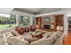 Inviting living room featuring stone fireplace, built-in shelving, plush seating, and large windows with scenic views at 2710 Gnarled Pine, Seabrook Island, SC 29455