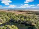 Expansive aerial view showcasing a scenic property with mature trees, a pond, and a distant ocean view at 2824 Old Drake Dr, Seabrook Island, SC 29455