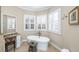 Relaxing bathroom featuring a standalone soaking tub beneath shuttered windows and a vanity with granite countertops at 2824 Old Drake Dr, Seabrook Island, SC 29455