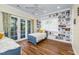 Bright bedroom with built-in shelving, French doors, and light-colored wood flooring at 2824 Old Drake Dr, Seabrook Island, SC 29455