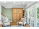 Bright living room with built-in cabinets, hardwood floors, French doors, and cozy seating near the staircase at 2824 Old Drake Dr, Seabrook Island, SC 29455