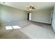 Large carpeted bedroom with a ceiling fan, a neutral color palette, and an open doorway at 3072 Adventure Way, Ladson, SC 29456
