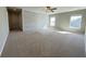 Spacious carpeted bedroom featuring a ceiling fan, three windows, and a whitewashed accent wall at 3072 Adventure Way, Ladson, SC 29456