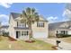 Charming two-story home featuring a palm tree, black shutters, a front porch, and a two-car garage at 315 Bradley Bend Dr, Moncks Corner, SC 29461