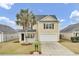 Charming two-story home featuring a palm tree, black shutters, a front porch, and a two-car garage at 315 Bradley Bend Dr, Moncks Corner, SC 29461