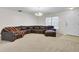 Bright living room with a large brown sectional sofa, neutral carpet, and a view of the front yard at 315 Bradley Dr, Moncks Corner, SC 29461