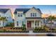 Charming two-story home with a porch swing, red door and manicured landscaping at sunset at 379 Oak Park St, Summerville, SC 29486